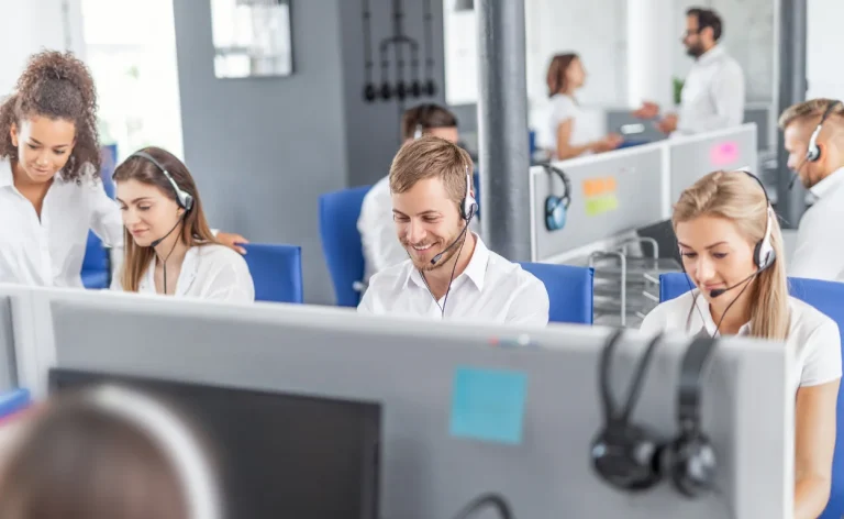 Call center agents working at ergonomic workstations with headsets and acoustic panel cubicles - Rochester Office Interiors